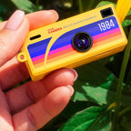 The yellow G6 held between fingers, showing its keychain-sized scale